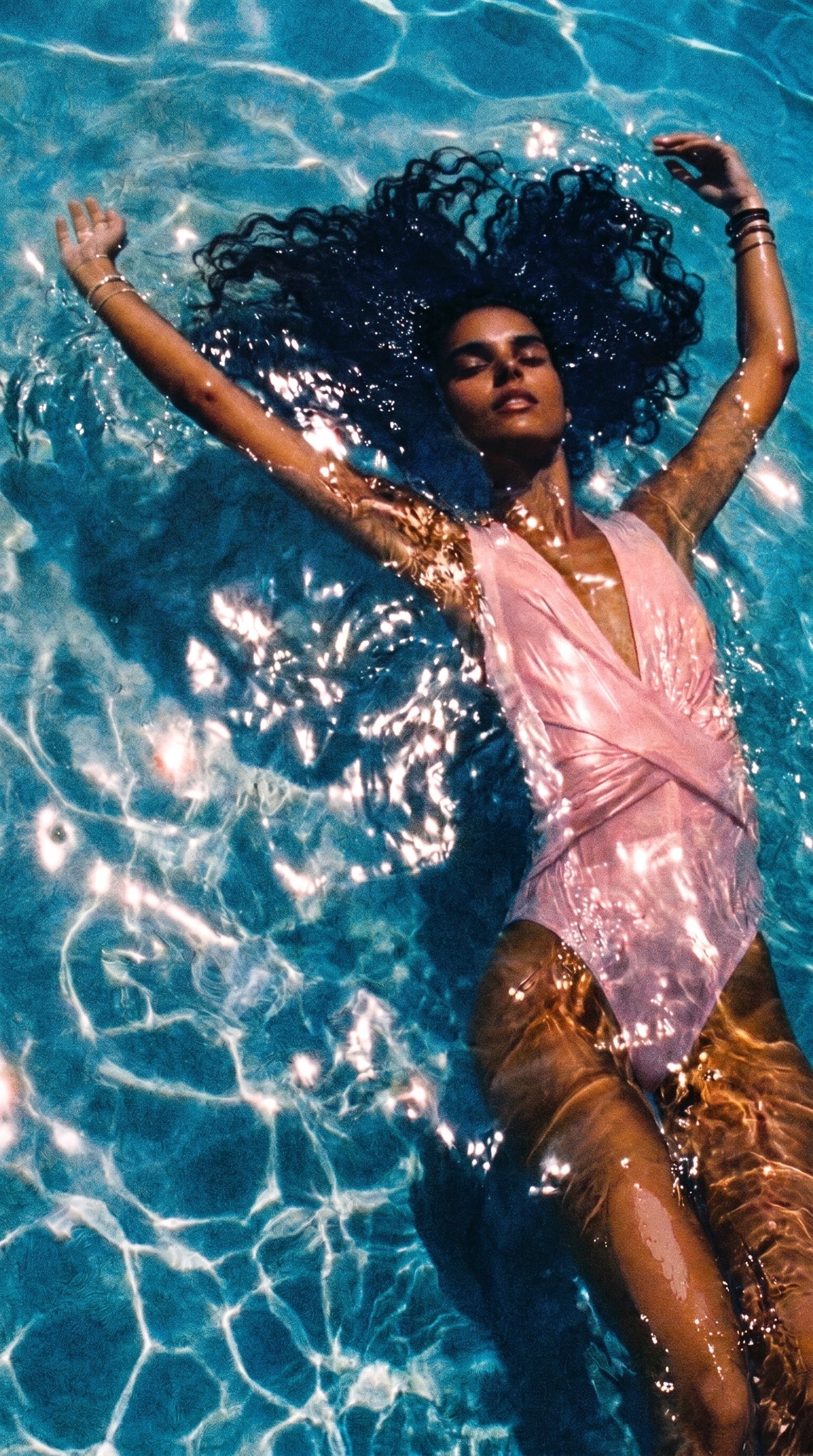 Mujer descansando en agua cristalina bajo la luz del sol